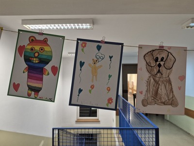 Galeria prac plastycznych uczniów na korytarzu szkolnym przedstawiająca  pluszowe misie