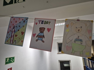 Galeria prac plastycznych uczniów na korytarzu szkolnym przedstawiająca  pluszowe misie