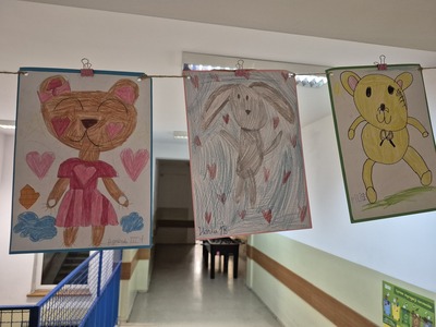 Galeria prac plastycznych uczniów na korytarzu szkolnym przedstawiająca  pluszowe misie