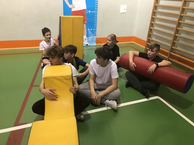 Uczniowie na sali gimnastycznej podczas zawodów sportowych.