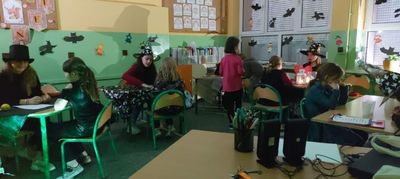 Świetlica. Przy stolikach wróżki, uczniowie i uczennice, którym przepowiadana jest przyszłość. Na ścianach i oknach przyklejone nietoperze i dynie.