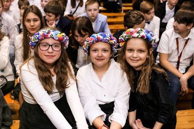 Widownia. W części centralnej trzy dziewczynki z wiankami w łowickich kolorach.
