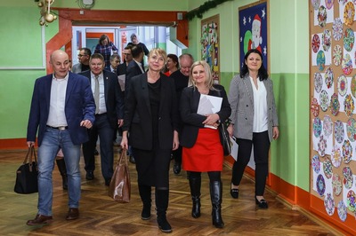 Korytarz szkolny. Goście zwiedzają szkołę.