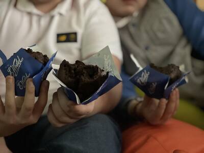 Muffiny czekoladowe w rękach dzieci - słodki poczęstunek ufundowany przez Radę Rodziców przy SP2 w Tuszynie dla wszystkich Uczniów.