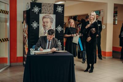 Pan Burmistrz wpisuje się do księgi pamiątkowej