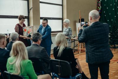 Pan Witold Wronka Prezes Stowarzyszenia Królewskie Miasto Tuszyn wraz z Panią Bożeną Okas wręczają upominki dla szkoły