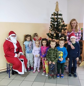 Święty Mikołaj i dzieci z oddziału przedszkolnego ubrane w piżamy