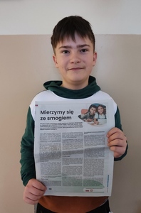 Uczeń pokazuje artykuł ESA "Mierzymy się ze smogiem" w Życiu Podkarpackim