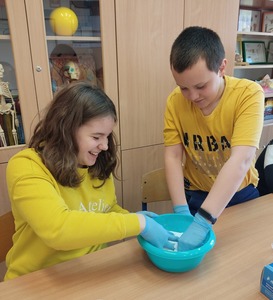 Uczniowie mieszają kwasek cytrynowy z sodą oczyszczoną oraz barwnikiem