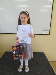 Uczennica klasy 0 z dyplomem i nagrodą za wygraną w ogólnopolskim konkursie plastycznym pt. "Kartka dla Ukrainy"