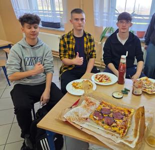 Uczniowie jedzą pizzę 