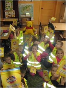 Uczniowie klas I w kamizelkach odblaskowych, które otrzymali od Policji w celu bezpiecznego poruszania się po drodze.