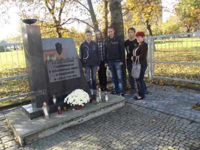 UCZESTNICY AKCJI PRZED POMNIKIEM DZIECI POMORDOWANYCH W OBOZIE W POGRZEBIENIU 1939-45