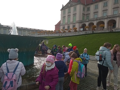 Grupa uczniów przy fontannie w Ogrodach Zamku Królewskiego w Warszawie.