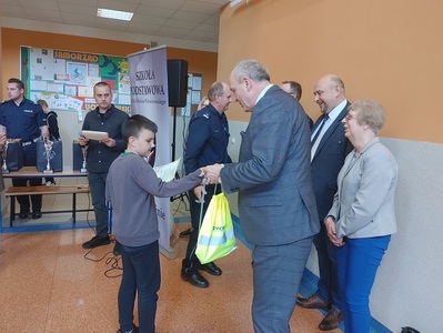 Uczeń odbiera nagrodę za zajęcie I miejsca w klasyfikacji indywidualnej w Grupie I. Na zdjęciu organ