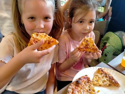 Dwie dziewczynki jedzą pizzę