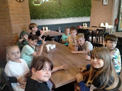 Uczniowie z klasy 2 siedzą w kręgielni