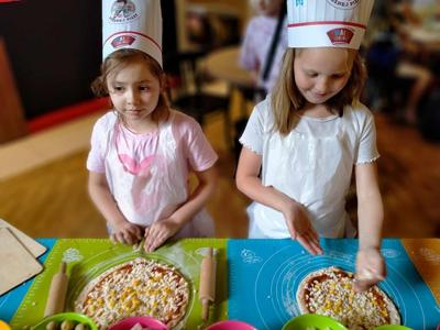 Dwie dziewczynki robią swoją pizze