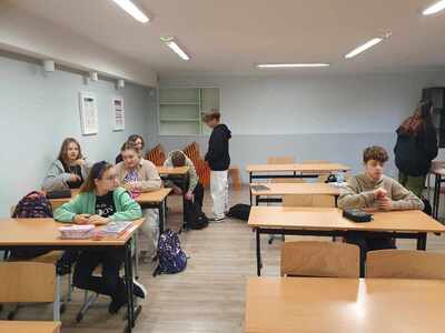 uczniowie w ławkach piszą kartkówkę