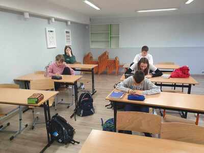 uczniowie w ławkach piszą kartkówkę
