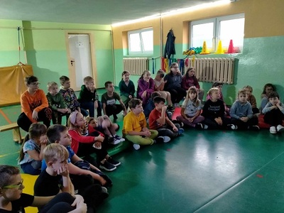 Uczniowie klasy 2 i 3 siedzą na podłodze