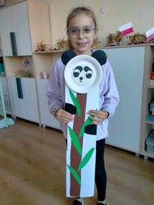 Dziewczynka trzyma swoją pracę plastyczną
