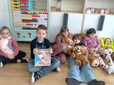 Dzieci siedzą na podłodze z misiami