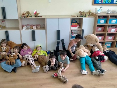 Dzieci siedzą na podłodze z misiami
