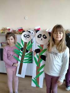 Dwie dziewczynki ze swoimi pracami plastycznymi.