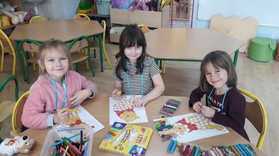 Dziewczynki siedzą przy stoliku i malują