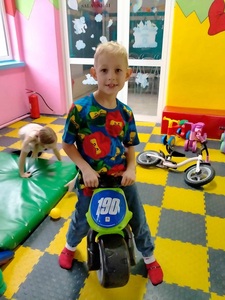 Chłopiec siedzi na motorku.