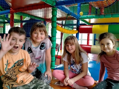 Trzy dziewczynki i jeden chłopiec siedzą blisko siebie