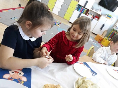 Dziewczynki składają sobie życzenia, dzielą się opłatkiem.