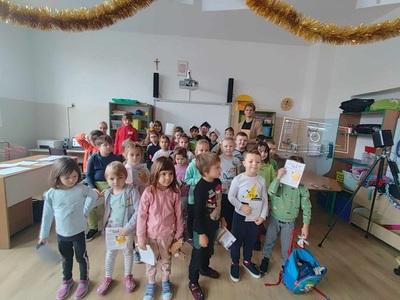 Dzieci z klasy 0 i 2 stoją razem za nimi pan