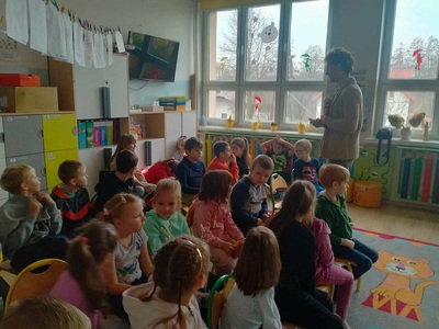 Dzieci siedzą na krzesełkach.