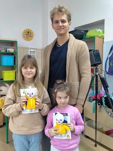 Dwie dziewczynki stoją z maskotkami za nimi pan