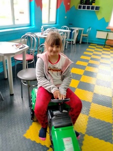 Dziewczynka jedzie na traktorku.