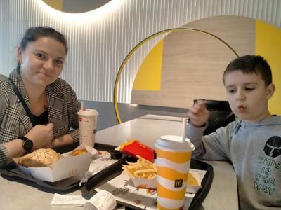 Chłopiec z nauczycielem siedzi w restauracji
