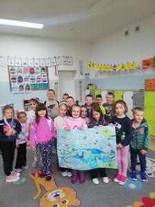 Na zdjęciu uczniowie trzymający pracę konkursową