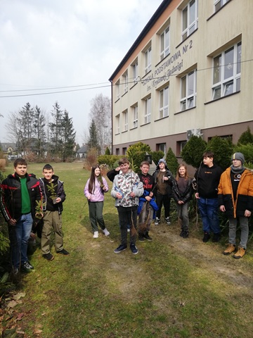 Na zdjęciu uczniowie trzymający drzewka