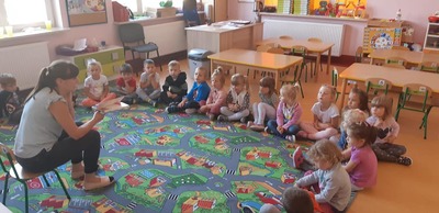 Wychowawca czyta dzieciom książkę