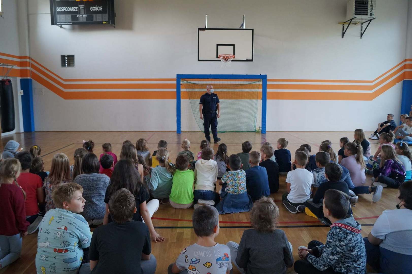 Policjant prowadzi pogadankę dla dzieci