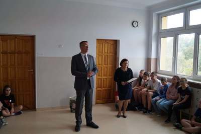 dyrektor mówi do siedzących uczniów