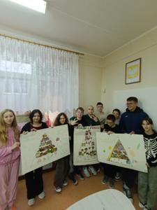 Na zdjęciu uczniowie klasy VII podczas realizacji projektu ,,Piramida Zdrowego Żywienia i Stylu Życia". Uczniowie trzymają w ręku plakaty. 