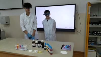 Dwóch uczniów kl. VIII podczas doświadczenia na lekcji chemii. 