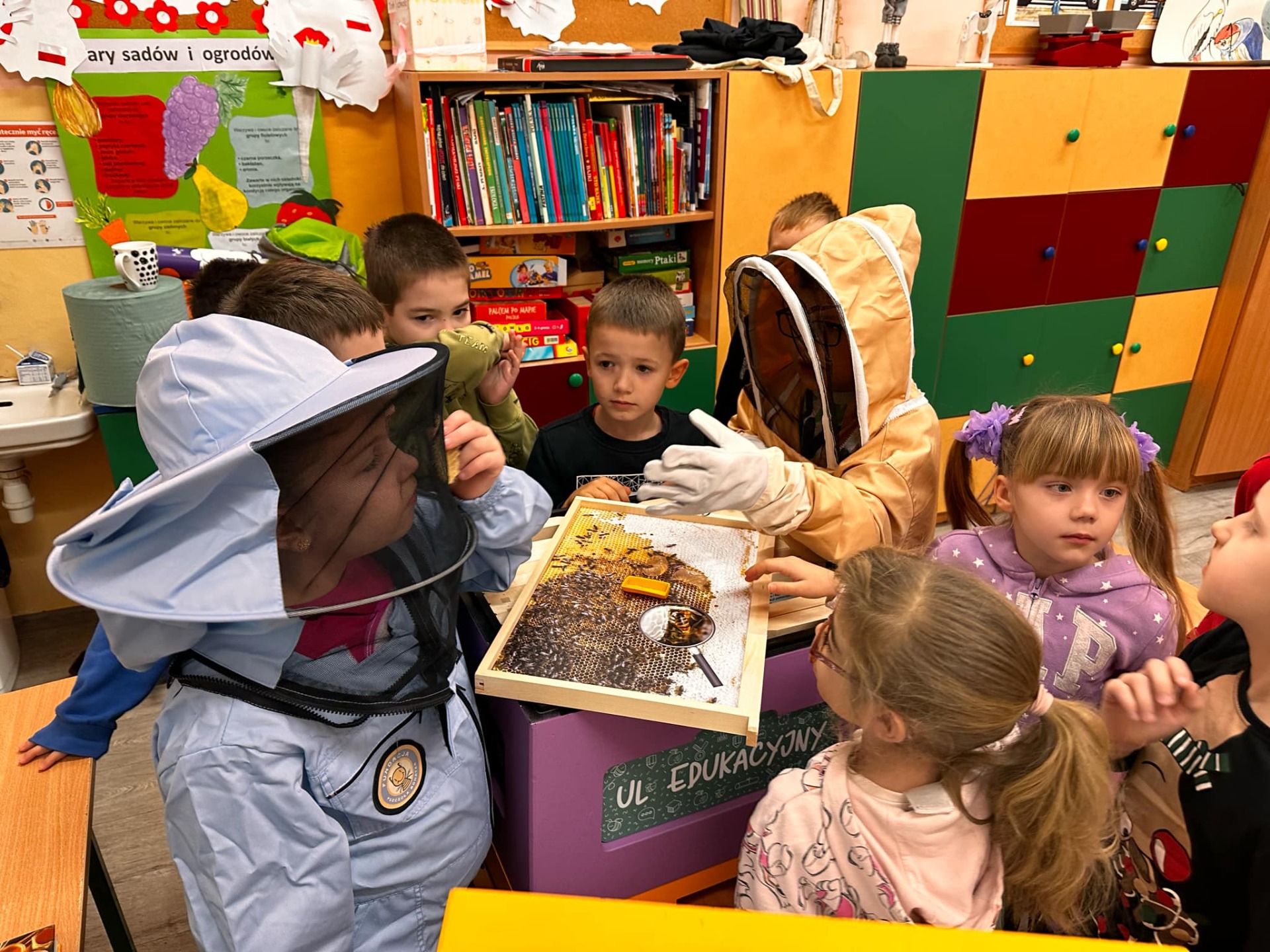 Grupa dzieci podczas zajęć edukacyjnych przy ulu.