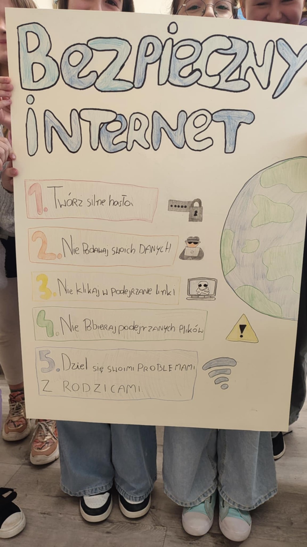 Uczniowie z wykonanym plakatem z okazji Dnia Bezpiecznego Internetu.
