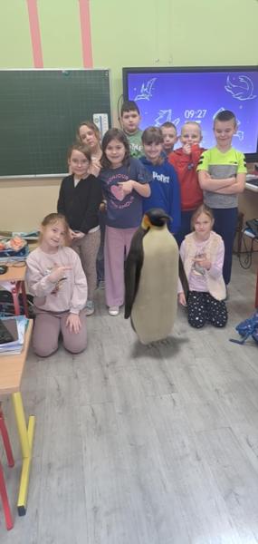 Uczniowie klasy drugiej w towarzystwie pingwina cesarskiego w 3D.