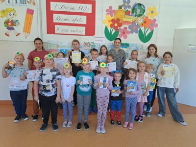 Na zdjęciu laureaci konkursu pt. "Wspomnienia z wakacji" wraz z organizatorkami - na tle dekoracji szkolnej.