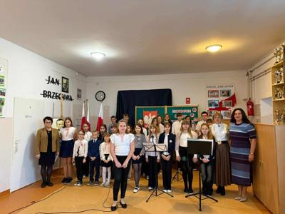 Zdjęcie grupowe uczniów klas 1,2,3,4,5 i 7 występujących podczas uroczystości z okazji odzyskania przez Polskę niepodległości. Na zdjęciu są również nauczyciele i dyrektor szkoły. 